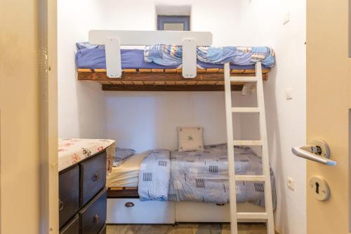 a bedroom with two bunk beds and a ladder at Kykladen White House in Koumáros