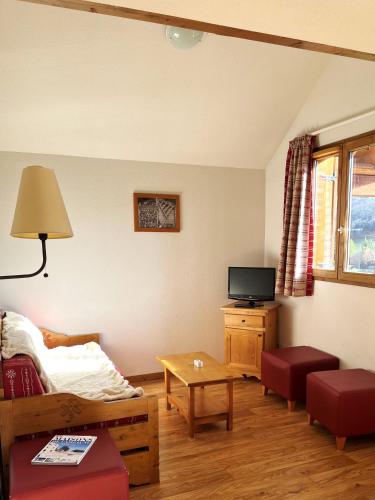 un salon avec un lit et une télévision dans l'établissement VVF Résidence Albiez-Montrond Maurienne, à Albiez-Montrond