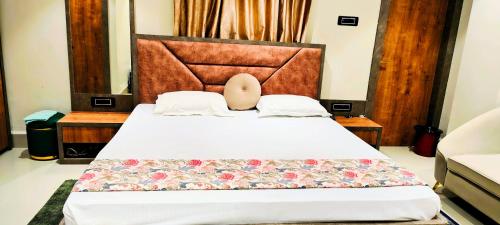 a bedroom with a large bed with a headboard at Manyavar Guest House Rooms & Family Service Flats in Deoghar