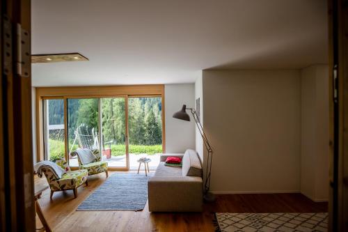 a living room with a couch and chairs and a window at Luxury Apartment with Mountain Views in Davos in Davos