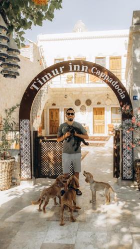 a man standing under an arch with two dogs at Timur inn Cappadocia in Goreme