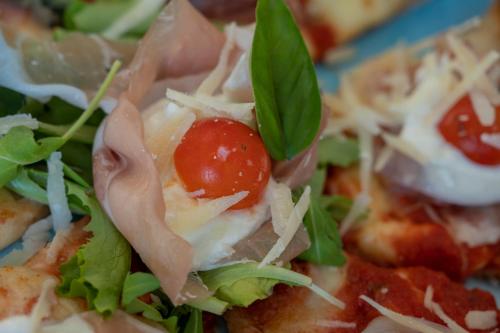 a close up of a pizza with a tomato on it at Al Pellegrino - Albergo Ristorante Pizzeria in Gradisca dʼIsonzo