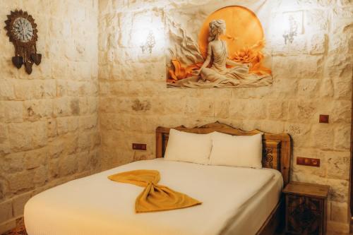 a bedroom with a bed with a painting on the wall at Timur inn Cappadocia in Goreme