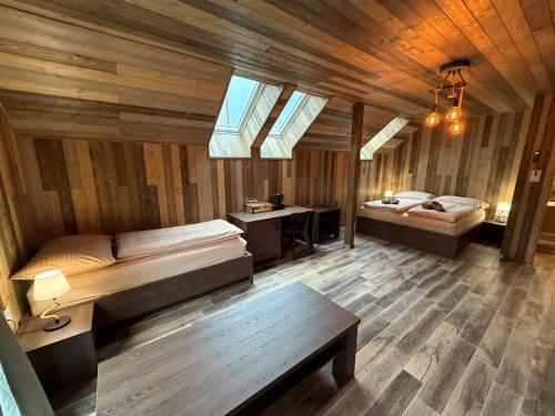 a bedroom with two beds in a room with wooden walls at Sklep "OSUD" in Mutěnice