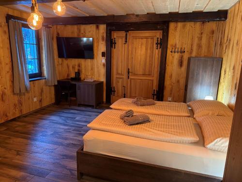 two beds in a room with wooden walls at Sklep "OSUD" in Mutěnice