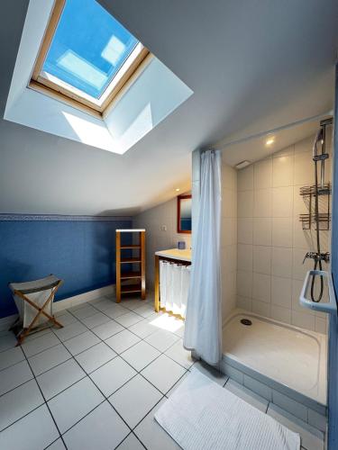 une grande salle de bain avec un puits de lumière et une douche dans l'établissement La Provençale - Piscine - Chambres climatisées, à Aubignan