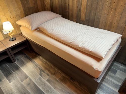 a bed in a room with a lamp and a table at Sklep "OSUD" in Mutěnice