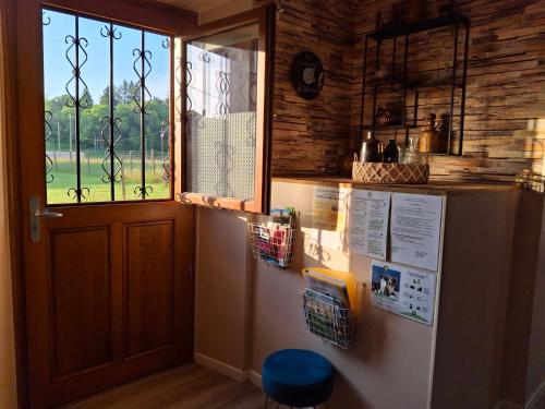 eine Küche mit Kühlschrank und Fenster in der Unterkunft Les Copains d'Abord in Beaucroissant