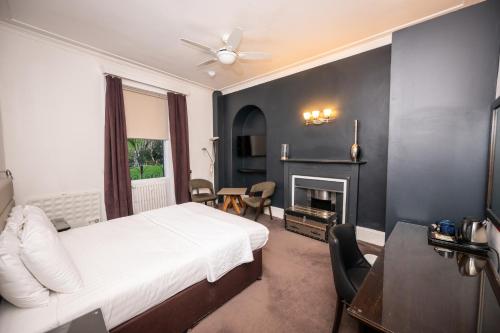 a hotel room with a bed and a fireplace at The Studley Hotel in Harrogate