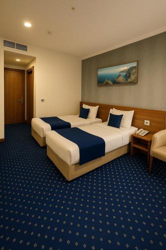 a hotel room with two beds in a room at Nova Sky Hotel in Erbil