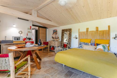 een slaapkamer met een bed en een tafel en een keuken bij Escapades Océanes in Sainte-Marie-de-Ré