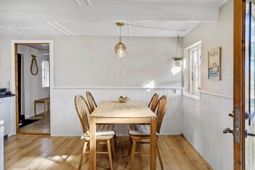 a dining room with a wooden table and chairs at 4024-Stege-Rabylille-Strandvej-14 in Stege