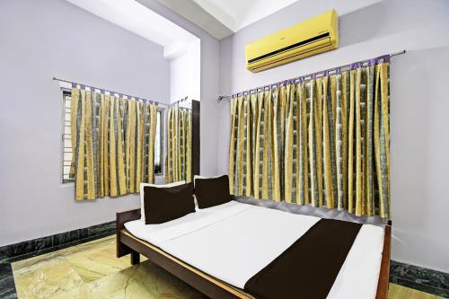 a bedroom with a bed and a window at Hotel O Arati House in Kolkata