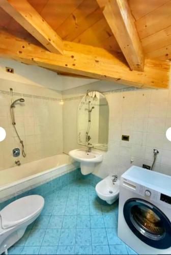 a bathroom with a toilet sink and a washing machine at Cèsa Niki in Canazei