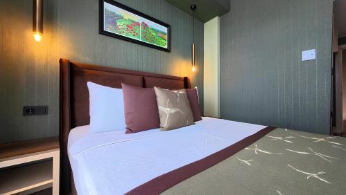 a bedroom with a bed with a tv on the wall at The Kirte Hotel in Eceabat