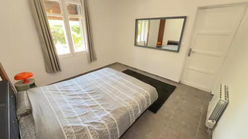 Un dormitorio con una cama y un espejo en la pared. en villa magui, en Aix-en-Provence