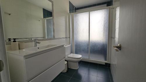 a bathroom with a sink and a toilet and a window at Villa Los Gemelos in Calpe