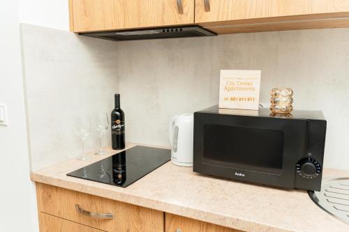 a microwave sitting on a counter with wine glasses at Apartamenty Cicha - bezpłatny parking in Krynica Zdrój