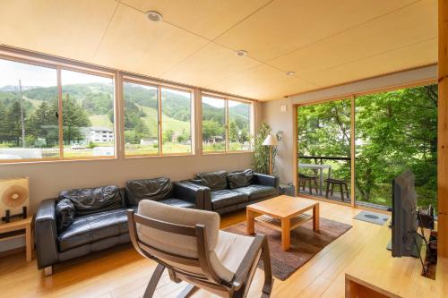 a living room with a couch and a table at Serenity & Solitude Chalets, walk to the lifts Happoone Ski Resort in Hakuba