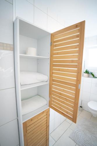 a bathroom with a closet with a wooden door at Charmante Wohnung am Drachenfels in Bad Honnef am Rhein