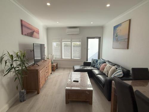 a living room with a couch and a table at Happy BNB at Beach side semaphore park in Port Adelaide