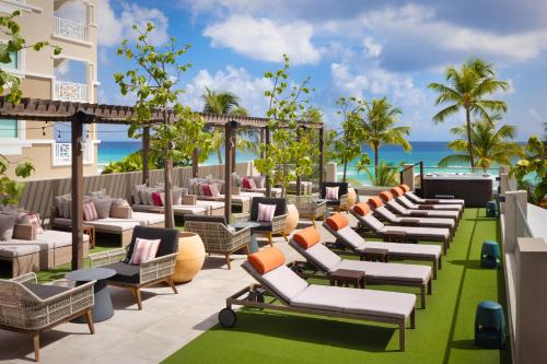 a hotel patio with lounge chairs and the ocean at O2 Beach Club & Spa All Inclusive by Ocean Hotels in Christ Church