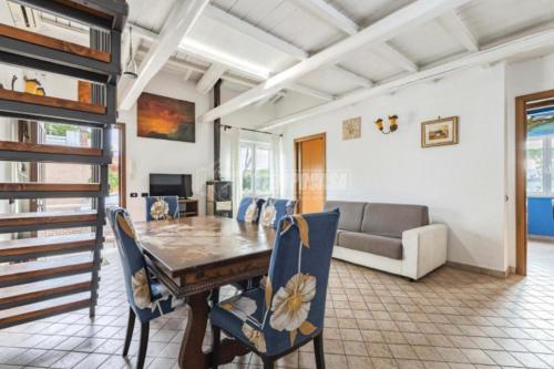 a dining room with a table and chairs and a couch at Casa di Clara Fregene in Fregene