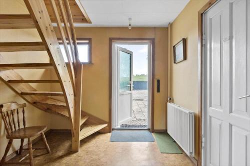 a hallway with a wooden staircase and a door at 4015-Stege-Sondre-Landevej-19 in Stege