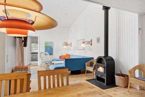 a living room with a blue couch and a fireplace at 4317-Stege-Oddermosevej-6 in Stege