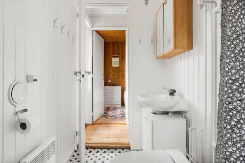 a bathroom with a sink and a toilet and a hallway at 4317-Stege-Oddermosevej-6 in Stege