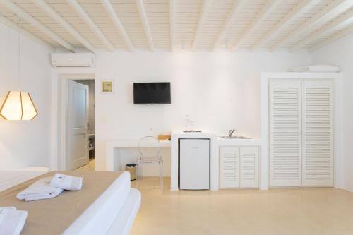 a white bedroom with a bed and a sink at Seethrough Mykonos Suites in Platis Yialos Mykonos