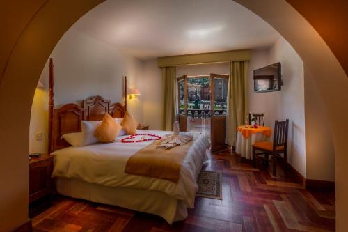 a bedroom with a bed and a dresser at El Virrey Boutique in Cusco