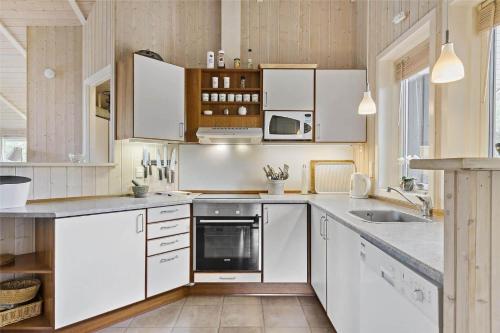 a kitchen with white cabinets and white appliances at 8157-Praesto-Svalevej-3 in Præstø