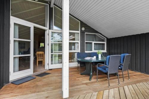 a screened in porch with a table and chairs at 8157-Praesto-Svalevej-3 in Præstø