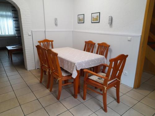 a table and four chairs with a table and a white table cloth at Ferienwohnung Bottrop Radetzki in Bottrop