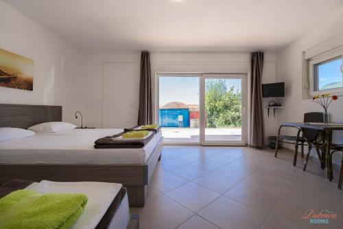a hotel room with two beds and a balcony at Dubrava Rooms in Dobra Voda