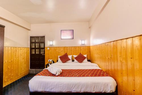 a bedroom with a large bed with wood paneling at Himalayan Gorkha Retreat in Darjeeling