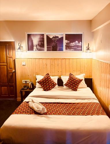 a bedroom with a large bed with pillows at Himalayan Gorkha Retreat in Darjeeling