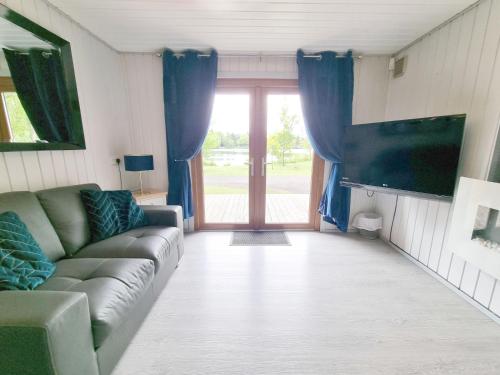 a living room with a couch and a sliding glass door at Oak Lodge 10 Hot Tub in York