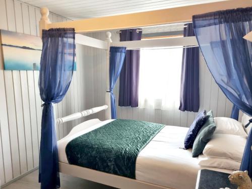 a bedroom with a bunk bed with blue curtains at Oak Lodge 10 Hot Tub in York