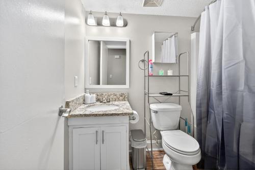 een witte badkamer met een toilet en een wastafel bij Styling Gem 5mins to Downtown pool-gym-parking in Durham