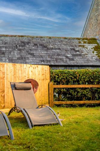 two chairs sitting in the grass in front of a fence at Trewhiddle Village cottage 42 in St Austell