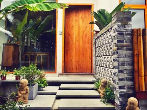two dolls sitting outside of a house with a door at Dan’s Sea Guest House Hangzhou in Hangzhou
