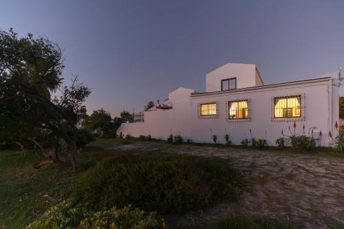 a white house with its lights on at Vlei Cove Guesthouse in Cape Town