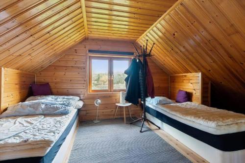 a bedroom with two beds in a wooden cabin at 8163-Praesto-Kohavevej-3 in Præstø
