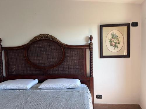 a bedroom with a wooden bed with two pillows at Casa Terragni 38 in Carpeneto