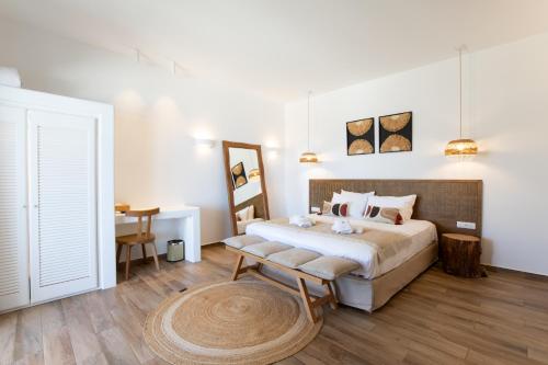 a bedroom with a large bed and a table at Seethrough Mykonos Suites in Platis Yialos Mykonos
