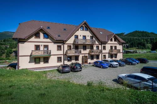 a large house with cars parked in front of it at Apartmány Ski Telgárt - Telgárt Resort in Telgárt