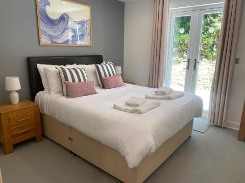 a bedroom with a large bed with towels on it at Trewhiddle Village cottage 42 in St Austell