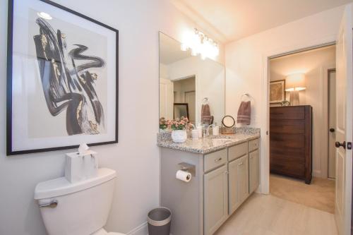 a bathroom with a toilet and a painting on the wall at Plains Getaway In Auburn in Auburn